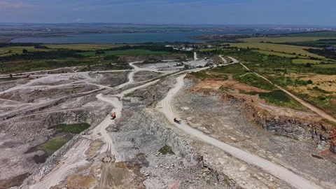 Construction site with trucks on roads in open quarry near water Stock Footage 339057825