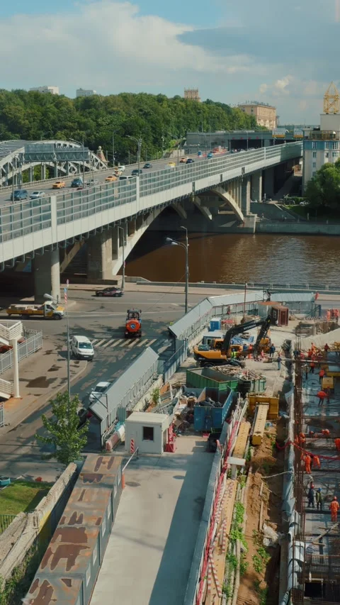 Construction site under city bridge with machinery and workers Vídeos de archivo 318090489