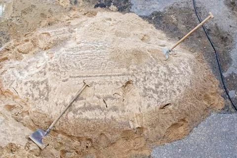 Construction site. View from top. Heap of sand and two shovels. Stock Photos