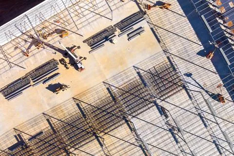 Construction site viewed from above featuring beams, tools, workers in works day Stock Photos