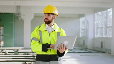 At construction site walking to the camera and working at laptop at the same Stock Footage 196313219