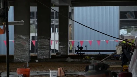 Construction site with warning flags worker carries pipe Stock Footage 81227313