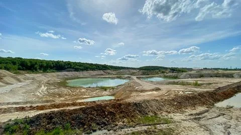 Construction site with water pools under a clear sky in a rural area during.. Stock Photos