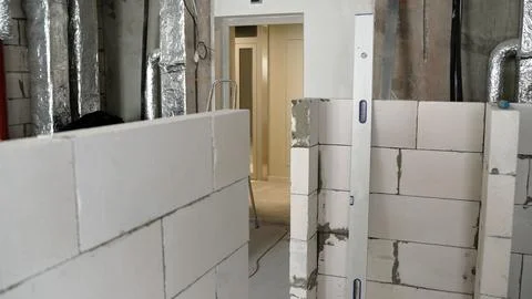 Construction site with white brick walls and insulation pipes 库存照片