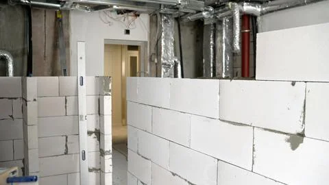 Construction site with white concrete blocks and exposed ductwork during in.. Fotos de archivo