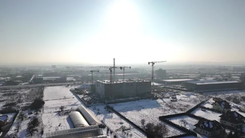Construction site in winter landscape with cranes and building progress visible Stock Footage 328365873