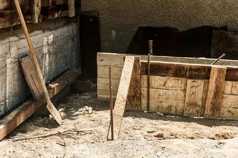 Construction site with wooden forms and tools on the ground, showing a part.. Fotos de archivo