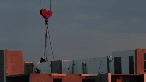 Construction site work with large crane hook lifting materials for building Stock Footage 323911977
