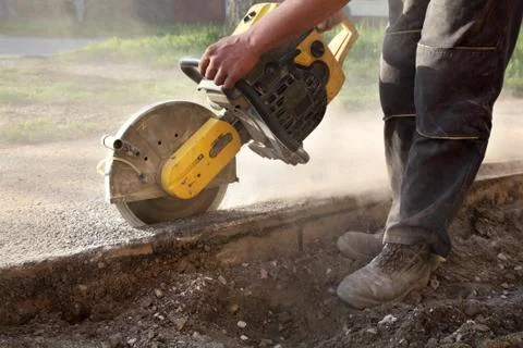 Construction site, worker cut asphalt with saw blade toll Stock Photos