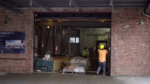 Construction site worker hardhat pulling down garage door brick building 4K NYC Stock Footage 74563878
