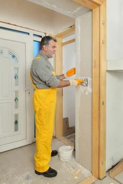 Construction site, worker installing gypsum board Stockfoto's