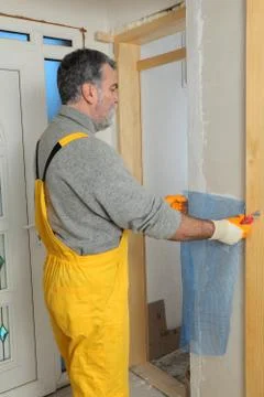 Construction site, worker installing gypsum board 写真素材