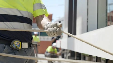 Construction site worker pulling rope with gloves and high vis clothing. Stock Footage 163691807