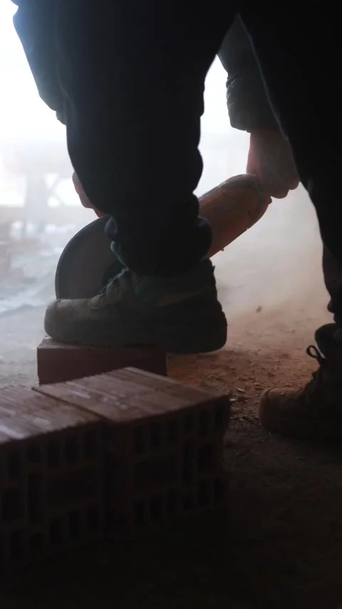 Construction Site: Worker Sawing Brick with Circular Saw Stock Footage 271586945