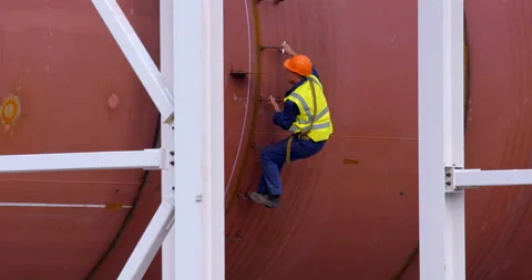 On a construction site, a worker in a vest and helmet makes measurements Stock Footage 161990712