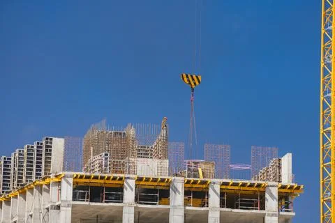 Construction site workers building a modern high-rise urban structure under a Stock Photos