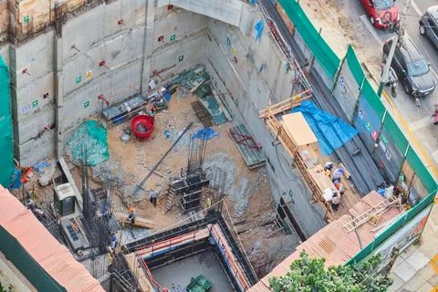 Construction site workers building a new foundation in urban city Stock Photos