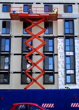 Construction Site Workers On Extending Aerial Platform Stock Photos