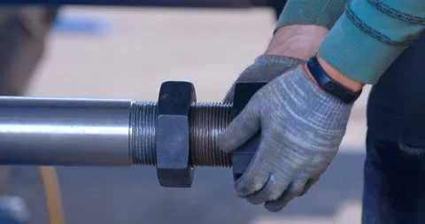 On a construction site, a worker's hands in gloves tightens a nut onto a shaft Video stock 161986866