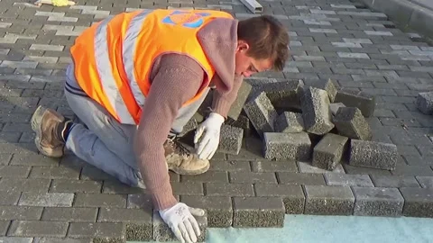 Construction site with workers laying interlocking concrete pavers. Close-up  Stock-Footage 303344842