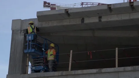 Construction Site Workers pan right tilt up to Towers with wooden structures  Stock Footage 81452976