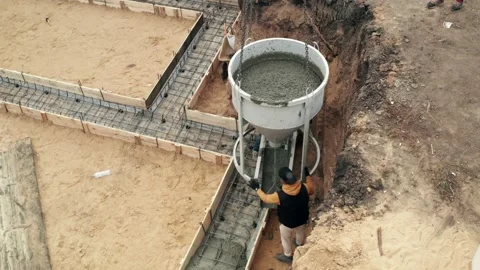 Construction site with workers pouring concrete in formwork with reinforcement Stock Footage 162864880