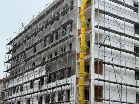 Construction site with workers on scaffolding. Progress, teamwork, and archit Stock Photos
