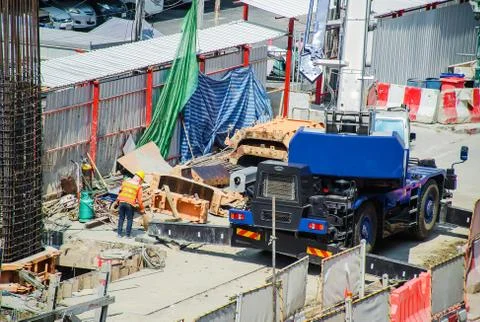 Construction site of workers working and trucks that break down the asphalt road Stock Photos