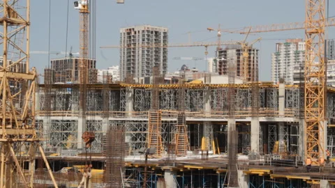 Construction site, working people, cranes, visible residential buildings, Stock Footage