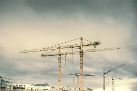 Construction site with yellow cranes on a cloudy day. Development area Stock Photos
