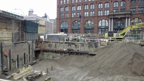 Construction site with yellow digger and pile of dirt building foundation NYC Stock Footage 71842178
