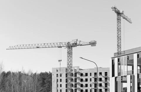 Construction site with yellow tower cranes and modern residential building .. Stock Photos