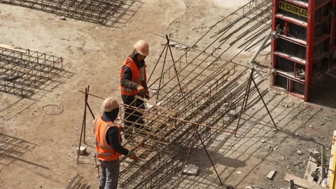 Construction site,caucasian  workers in helmets uniforms.structures from iron Stock Footage 172137850