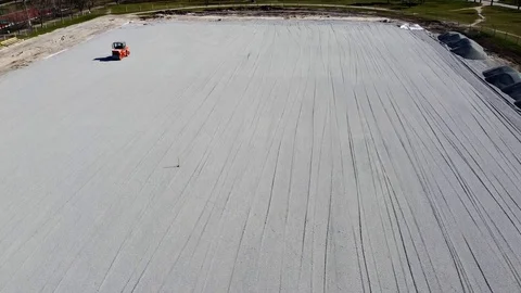 Construction of the stadium, paver rides. Drone shooting Stock Footage 128363965