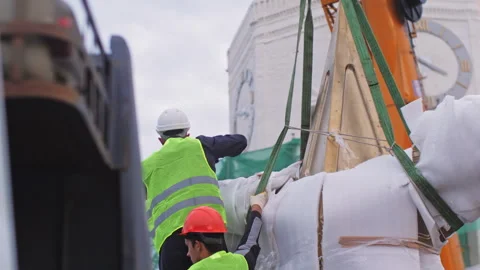 Construction staff secures wrapped star on crane hook using cords Vídeo Stock 258469362