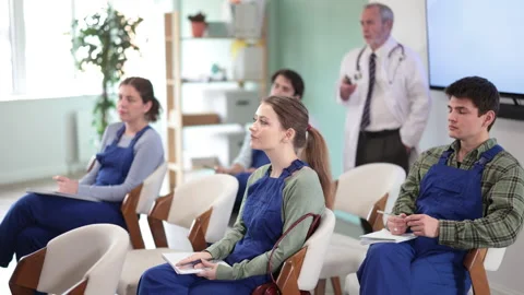 Construction students listen to a medical lecture against the background of a Stock Footage 344851649