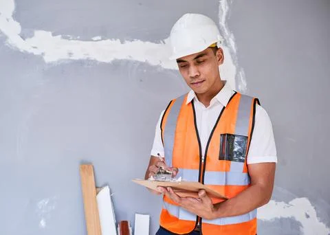 A construction supervisor checks renovation project with checklist on clipboard Stock Photos