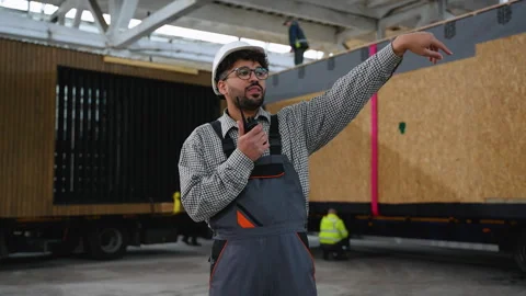 Construction supervisor communicating with walkie talkie and giving instructions Stock Footage 313085700