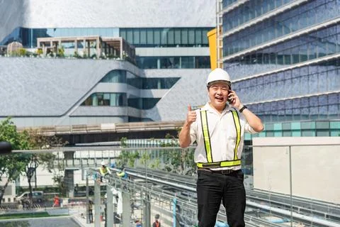 Construction supervisor smiling and giving thumbs up while coordinating con.. 스톡 사진