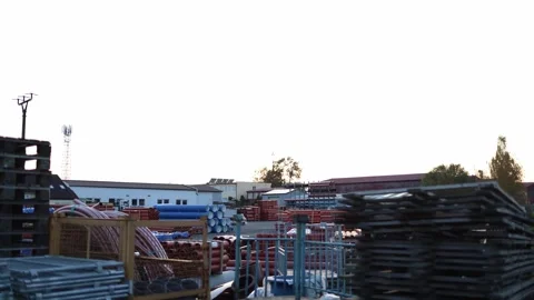 Construction supply store outdoor yard with stacks of pipes and metal parts unde Stock Footage 319833079