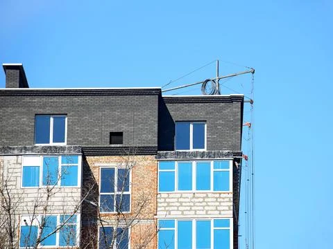Construction suspended cradle for robots with a facade of a high-rise multi.. Stock Photos
