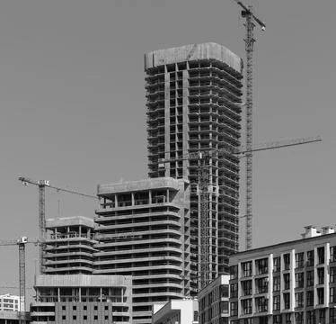 Construction of tall residential tower in developing city district. Cranes an Foto stock