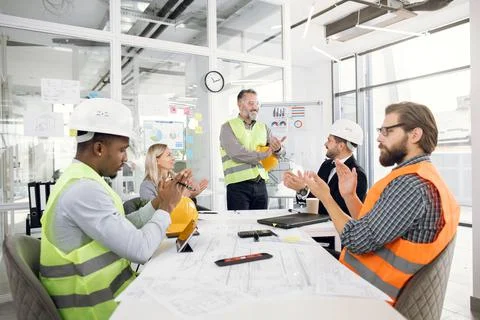 Construction team applauding during presentation of project Stock Photos