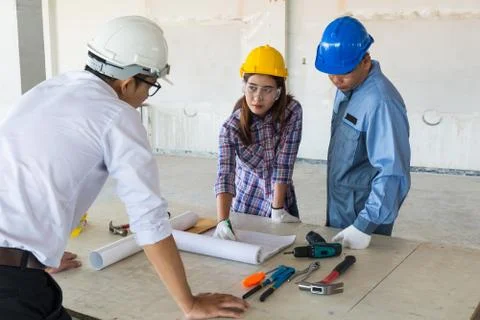 Construction team, Architect, Engineer and Foreman discussing Stock Photos