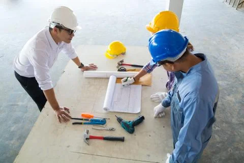 Construction team, Architect, Engineer and Foreman discussing Stock Photos