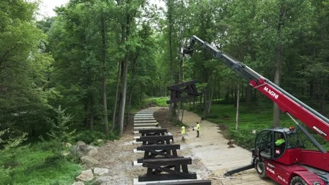 Construction Team Builds Bridge in Wooded Area During Daytime Work Session Video stock 327611183