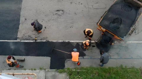 Construction team spreading fresh hot asphalt with shovels and a rake behin.. Stock-Footage 339802299