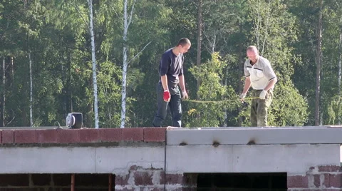 Construction team of two people in a sultry hot summer day working on the top Stock Footage 61840720