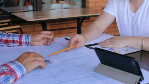 Construction team working on construction drawings in an office Stock Footage 120838503