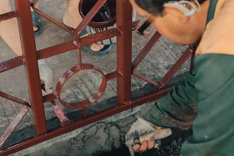 Construction technicians with hearing aid working with cement paving, mix wit Stock Photos
